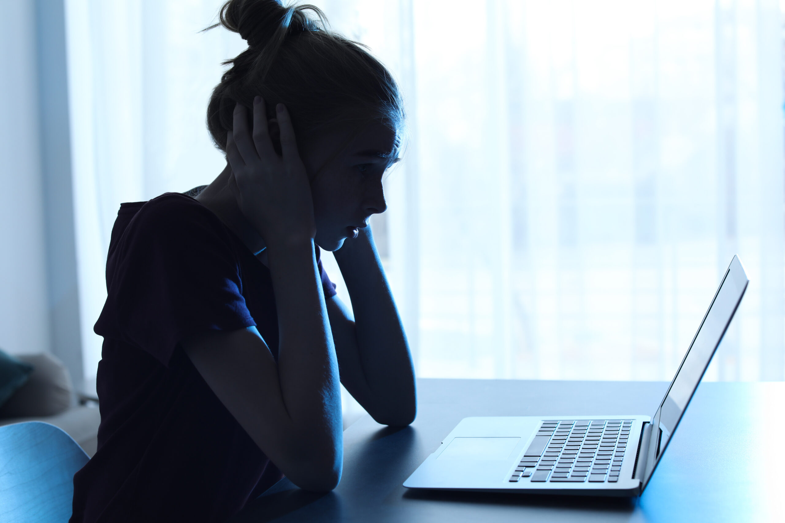 Terrified,Teenage,Girl,With,Laptop,At,Table,Indoors.,Danger,Of