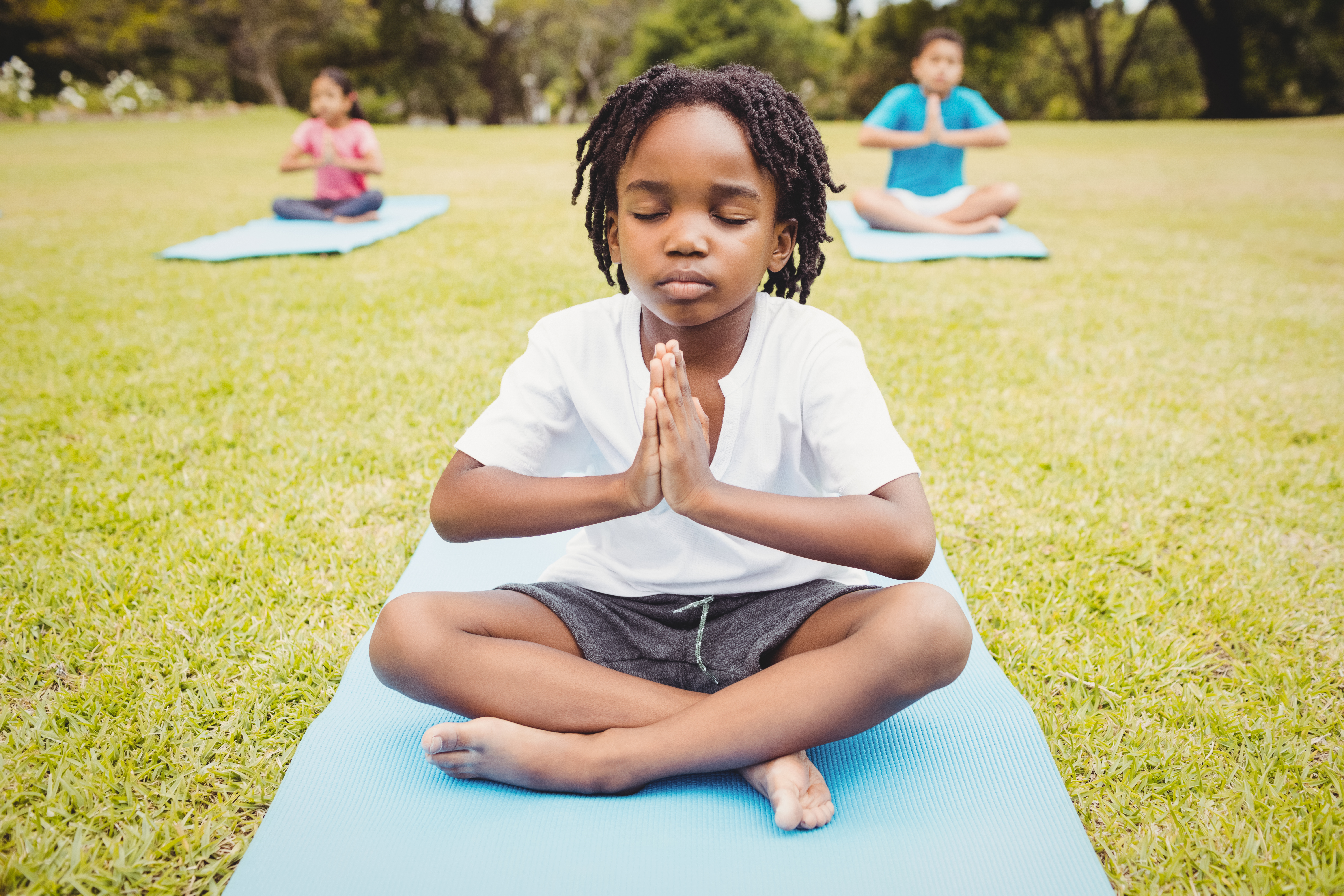 Portrait,Of,Child,Doing,Yoga,With,Friends,In,The,Park
